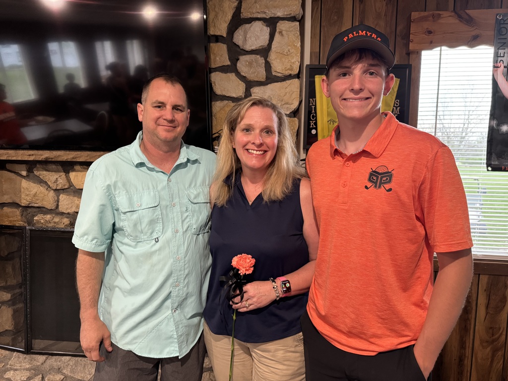 Senior night recognition, student with parents holding orange carnation