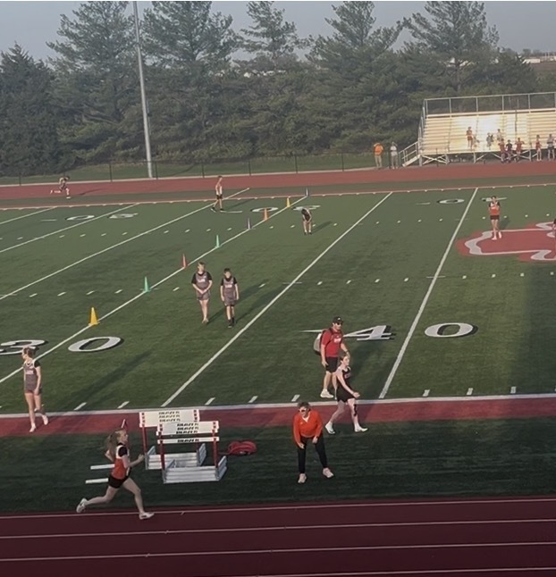 student and coach on track during track competition
