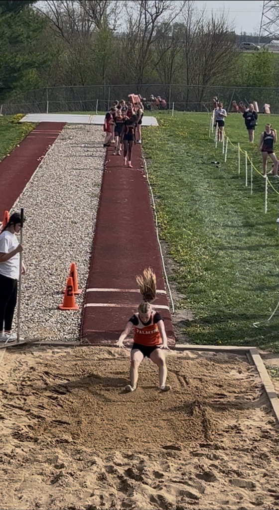 student jumping into sand pit in long jump competition