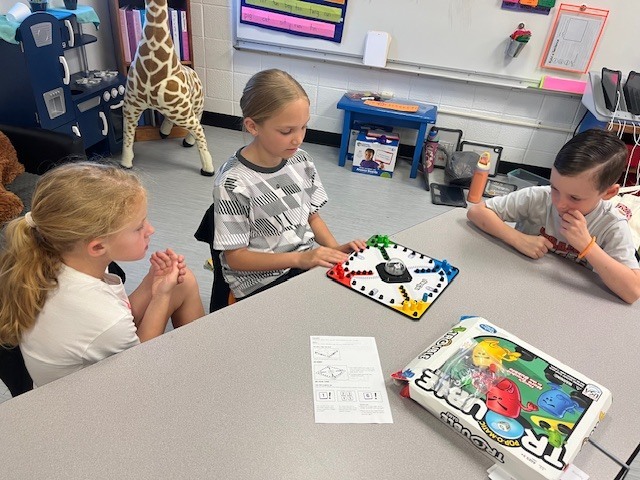 4th grade PACE student playing a game with kindergarten students