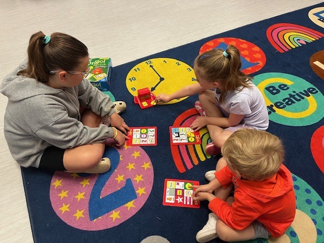 4th grade PACE student playing a game with kindergarten students