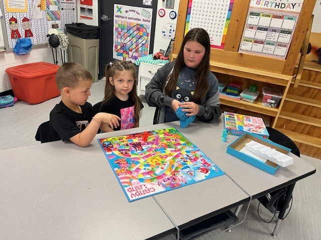 4th grade PACE student playing a game with kindergarten students