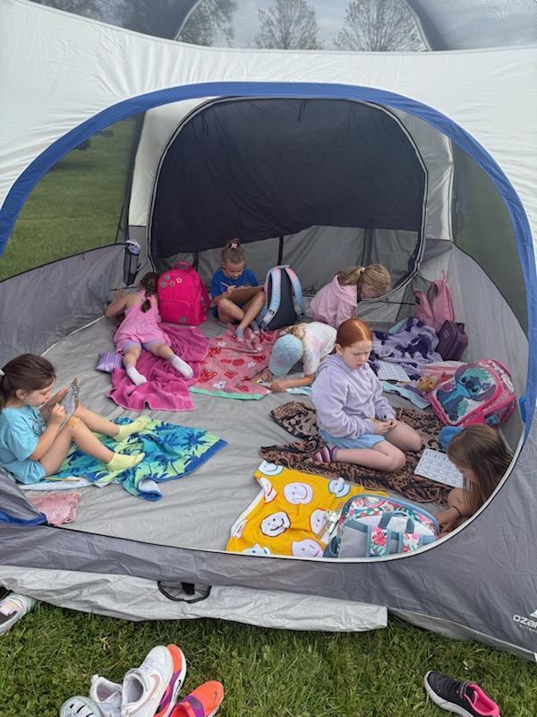 Kindergarten students exploring nature outside today inside a tent