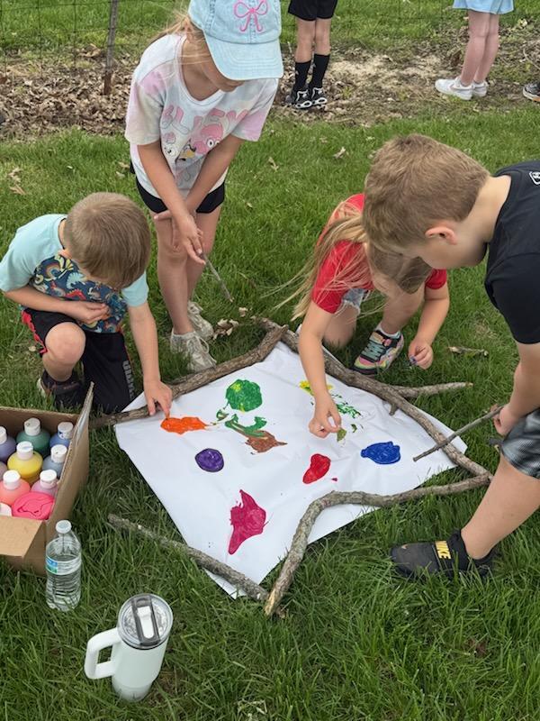 Kindergarten students exploring nature outside today painting