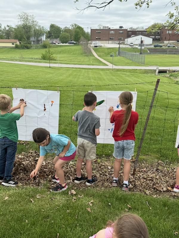 Kindergarten students exploring nature outside today painting