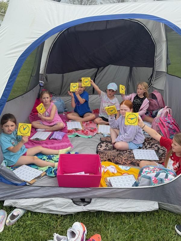 Kindergarten students exploring nature outside today inside a tent