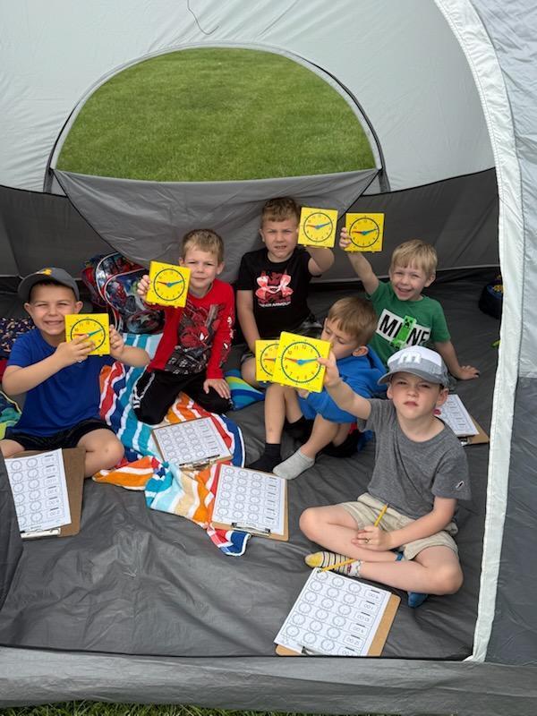 Kindergarten students exploring nature outside today inside a tent