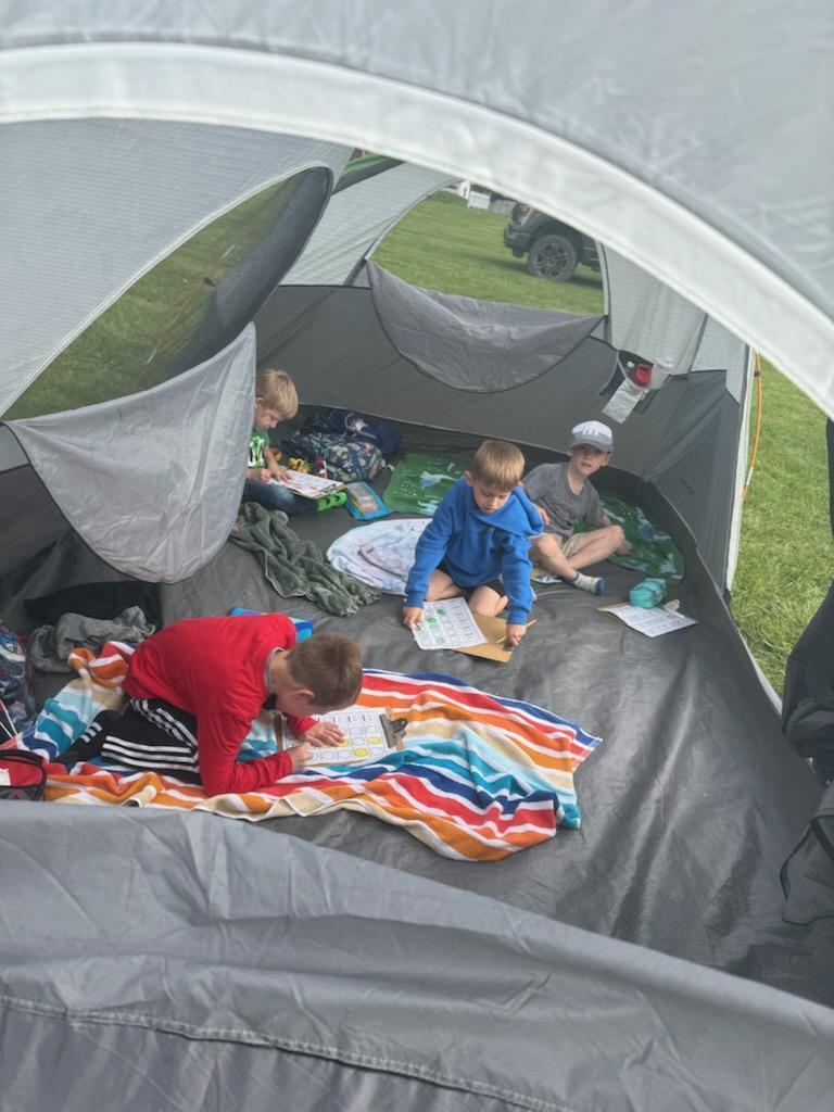 Kindergarten students exploring nature outside today inside a tent