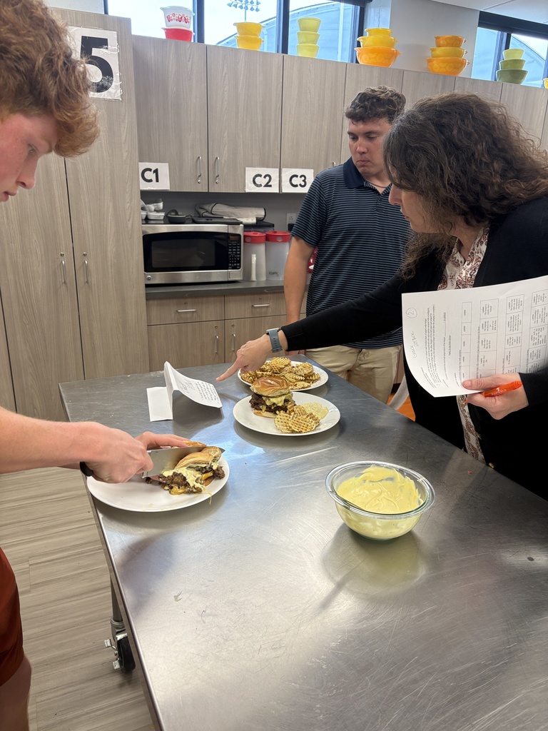 Judges and student tasting their burger and fries in Foods class