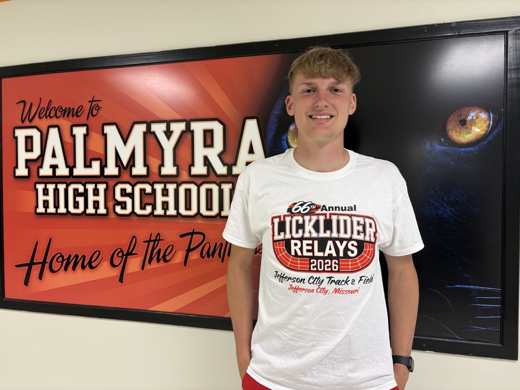 Student in front of Palmyra High School sign wearing a track tshirt