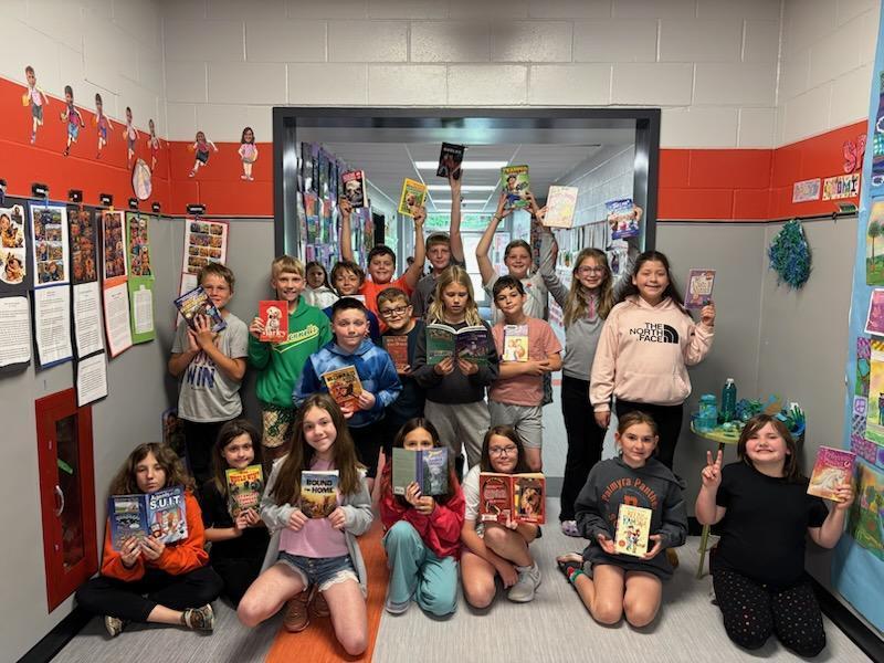 4th grade students with books from classroom book exchange