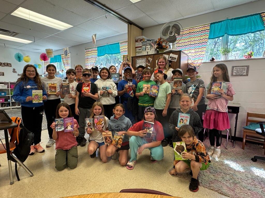 4th grade students with books from classroom book exchange