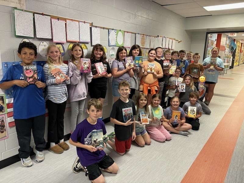 4th grade students with books from classroom book exchange