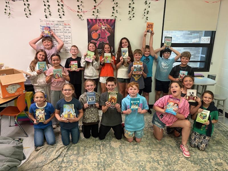 4th grade students with books from classroom book exchange