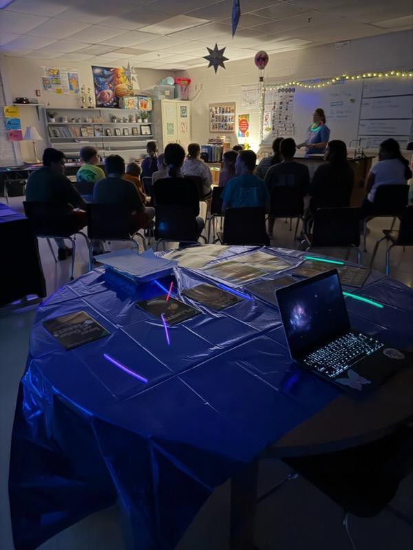 Science lesson on space at Palmyra Middle School, classroom dark with lights and students listening