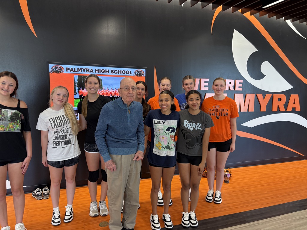 Mr Lenzini viewing the gym renovations posing with pom squad