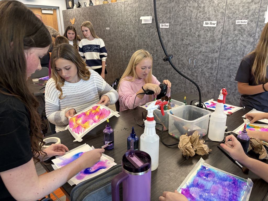 students working with watercolor paint to create colorful artwork