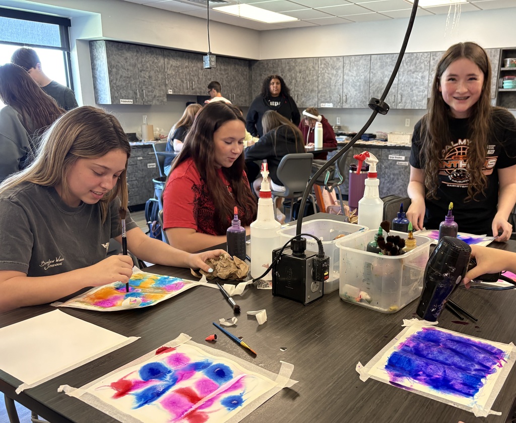 students working with watercolor paint to create colorful artwork