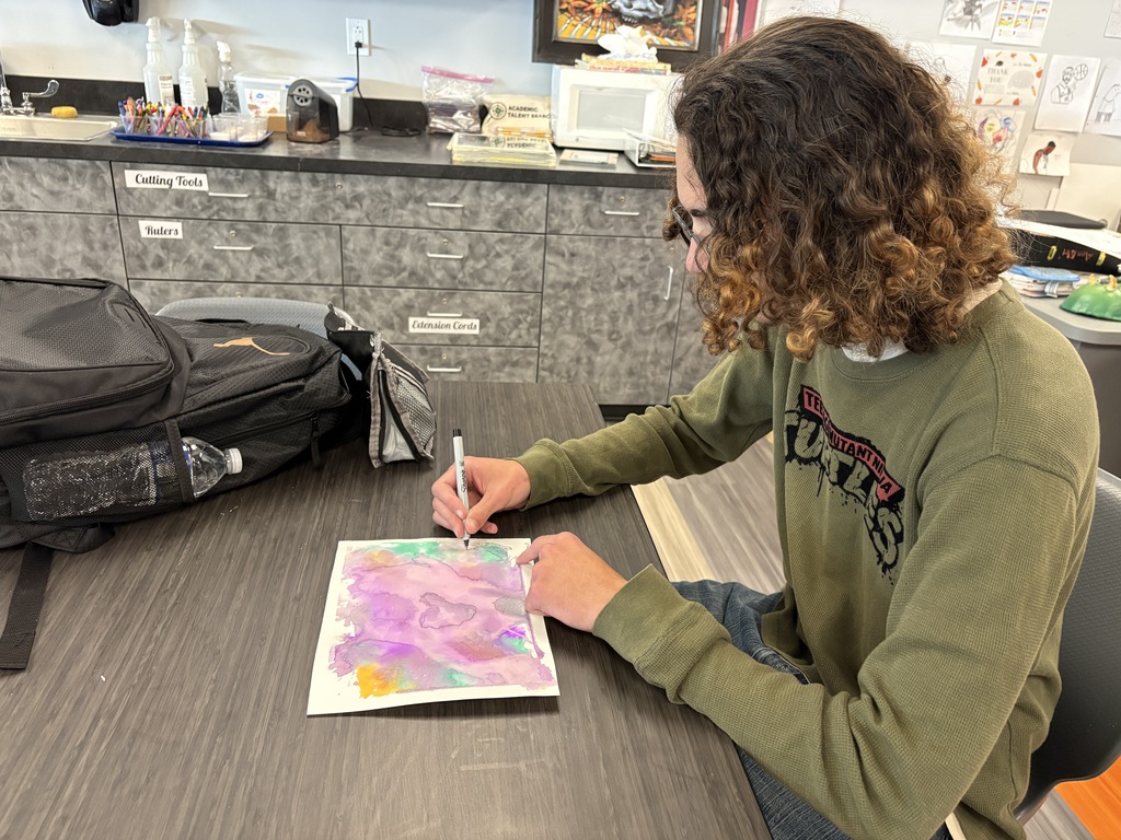student working with watercolor paint to create colorful artwork