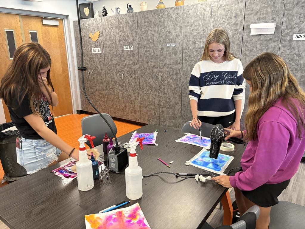 students working with watercolor paint to create colorful artwork