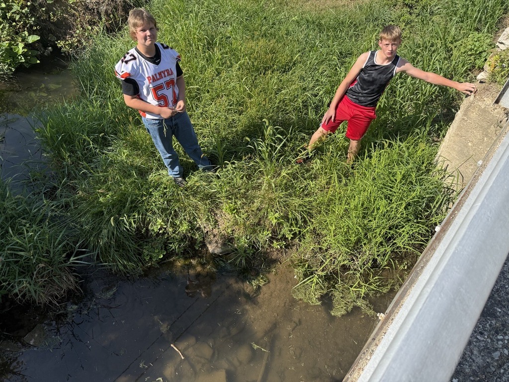 2 students observing habitat in creek near middle school