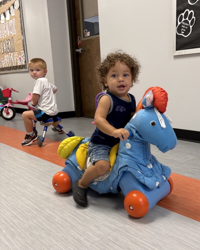 PAT playgroup participants riding on toys