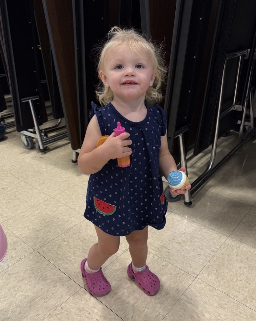 PAT playgroup participant playing with plastic food and baby bottle