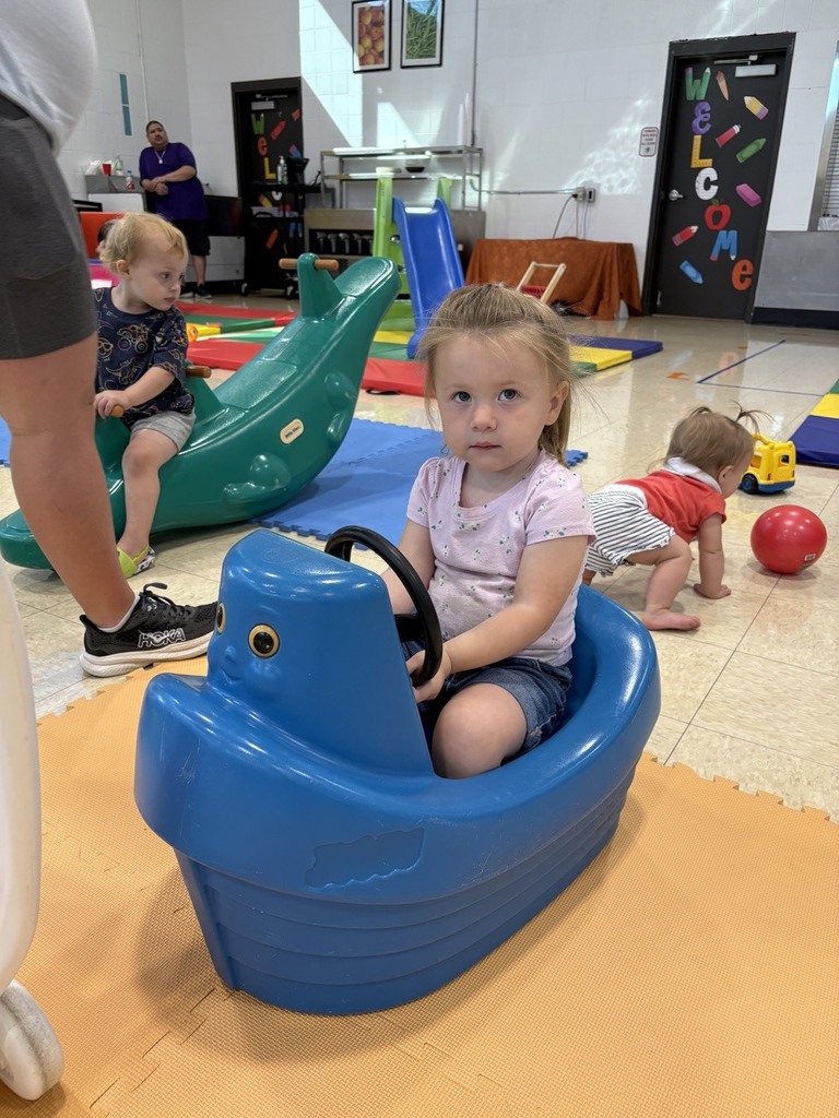 PAT playgroup participant riding on blue boat