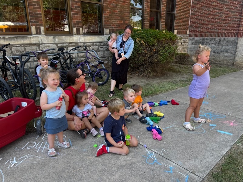 child care students waving at school buses outside middle school