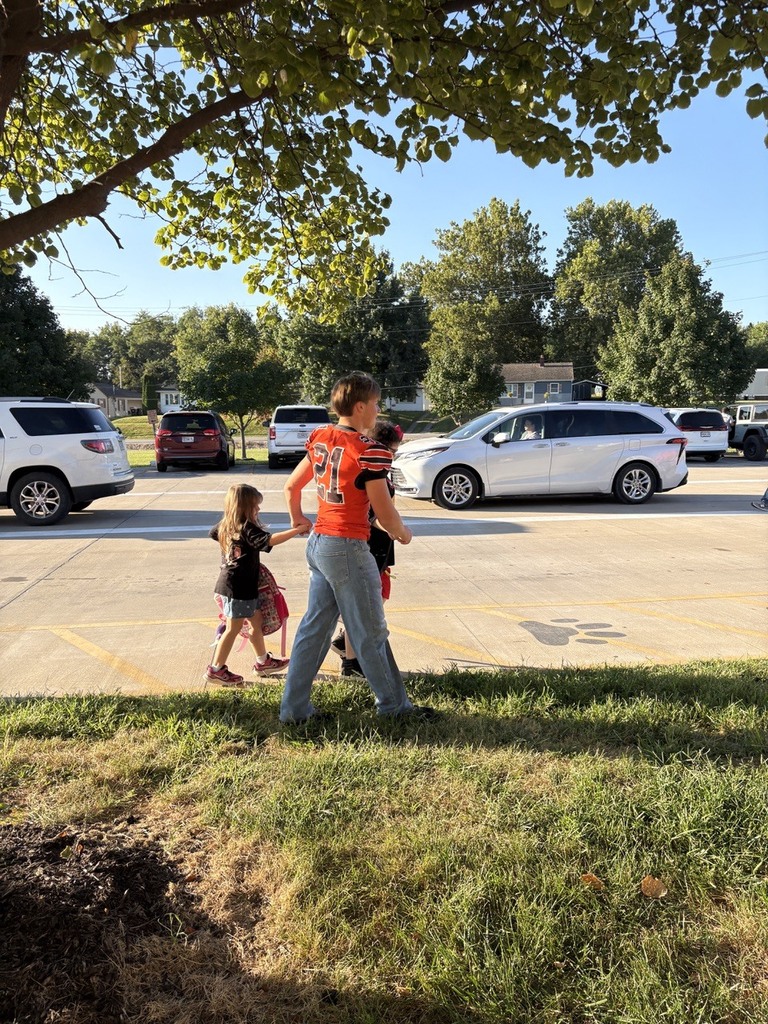 Football player walking students into school