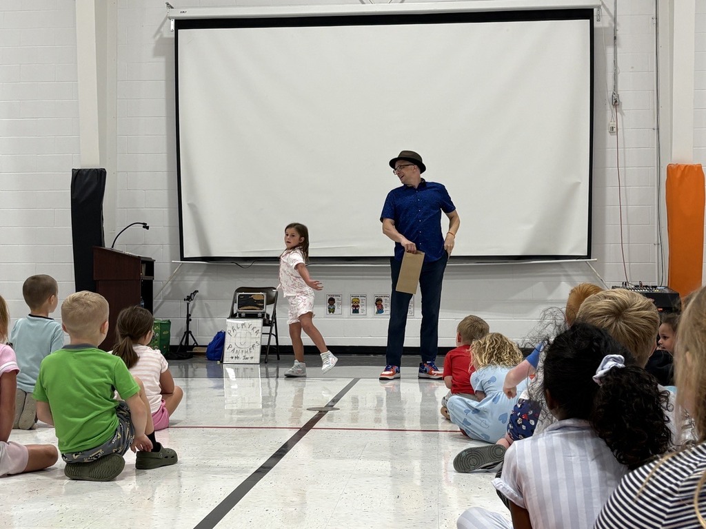 girl throwing a ball while Man watches during assembly