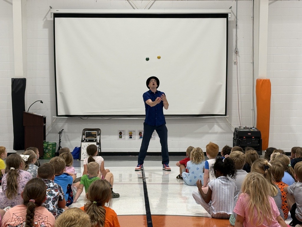 Man juggling while students watch during assembly