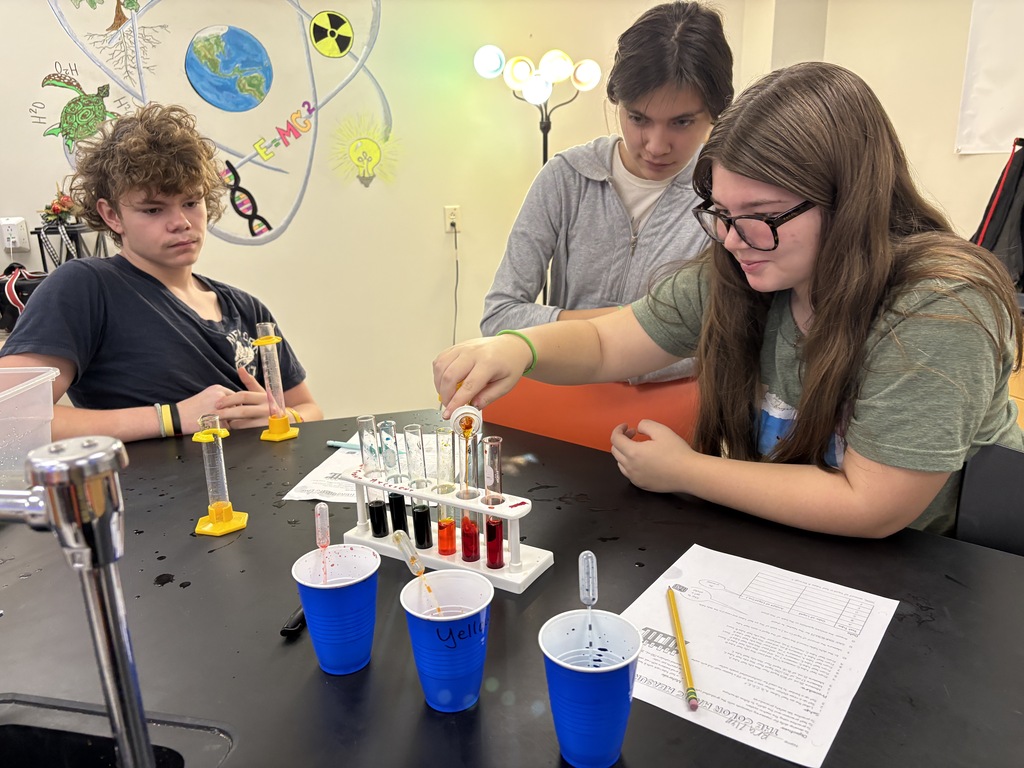 students measuring colored liquid into test tubes