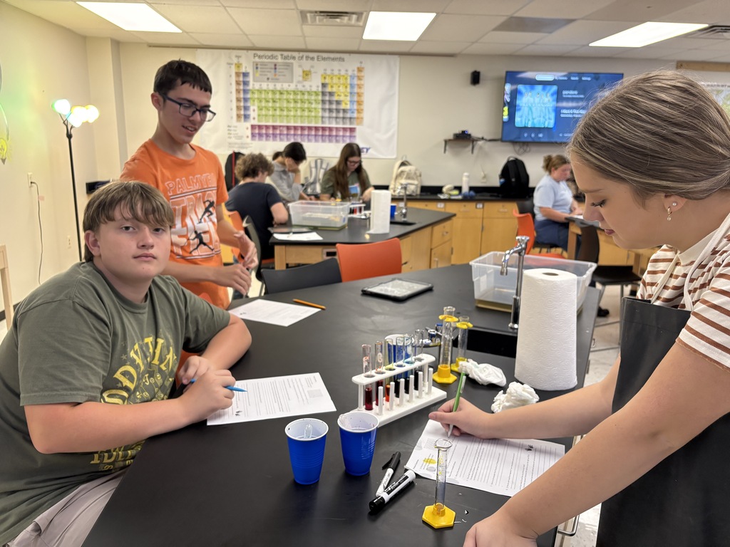 students measuring colored liquid into test tubes lab