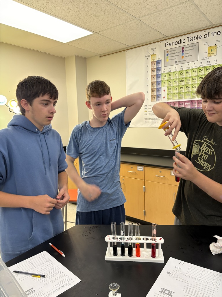 students measuring colored liquid into test tubes