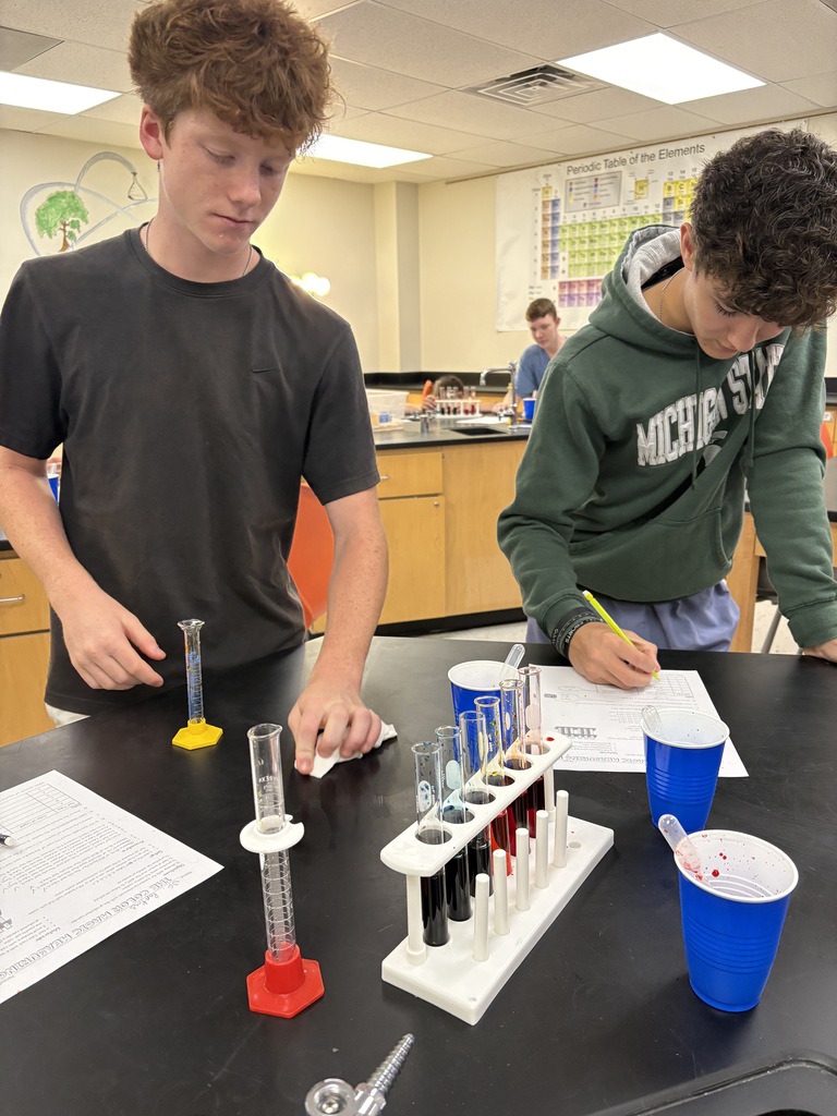 students measuring colored liquid into test tubes
