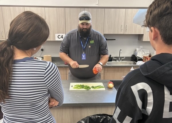 Mr Haeberlin demonstrating proper knife handling skills to students