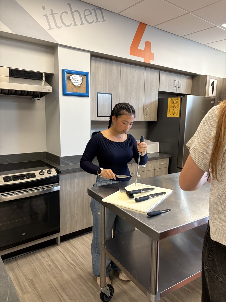 Foods class student practicing knife sharpening