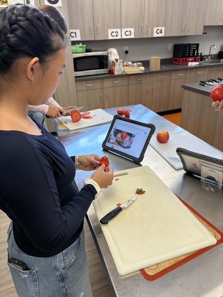 student creating fruit roses