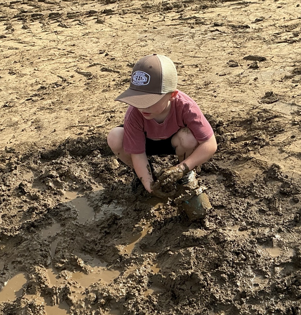 young child playing in mud