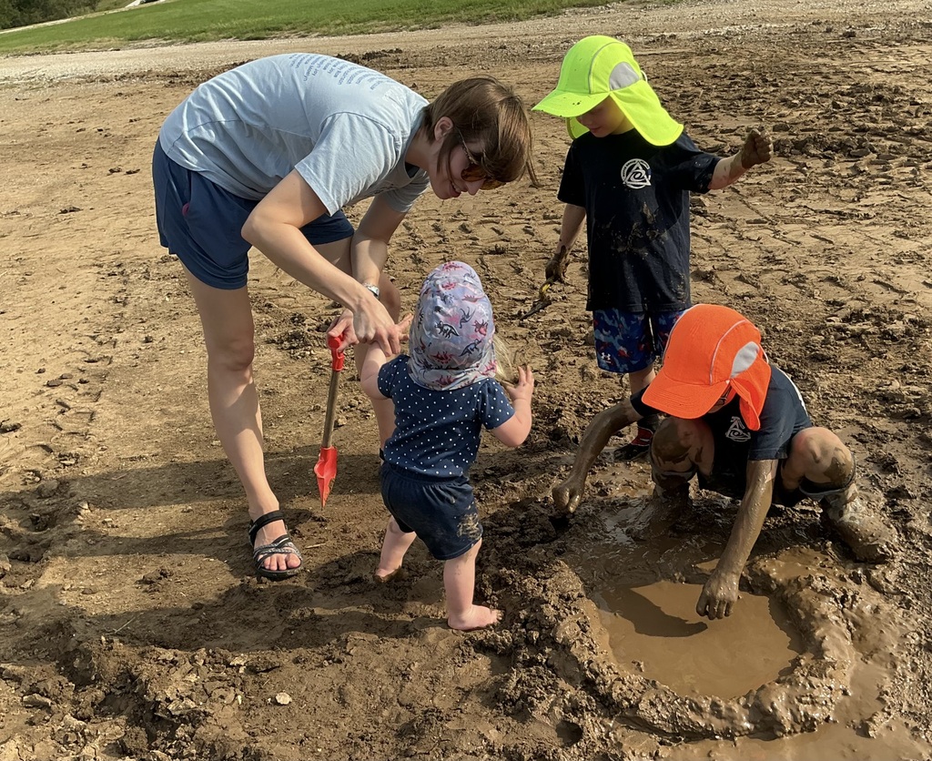 young children playing in dirt with shovels and mud