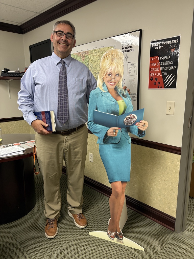 Mr Harper with Dolly Parton cutout reading their favorite books