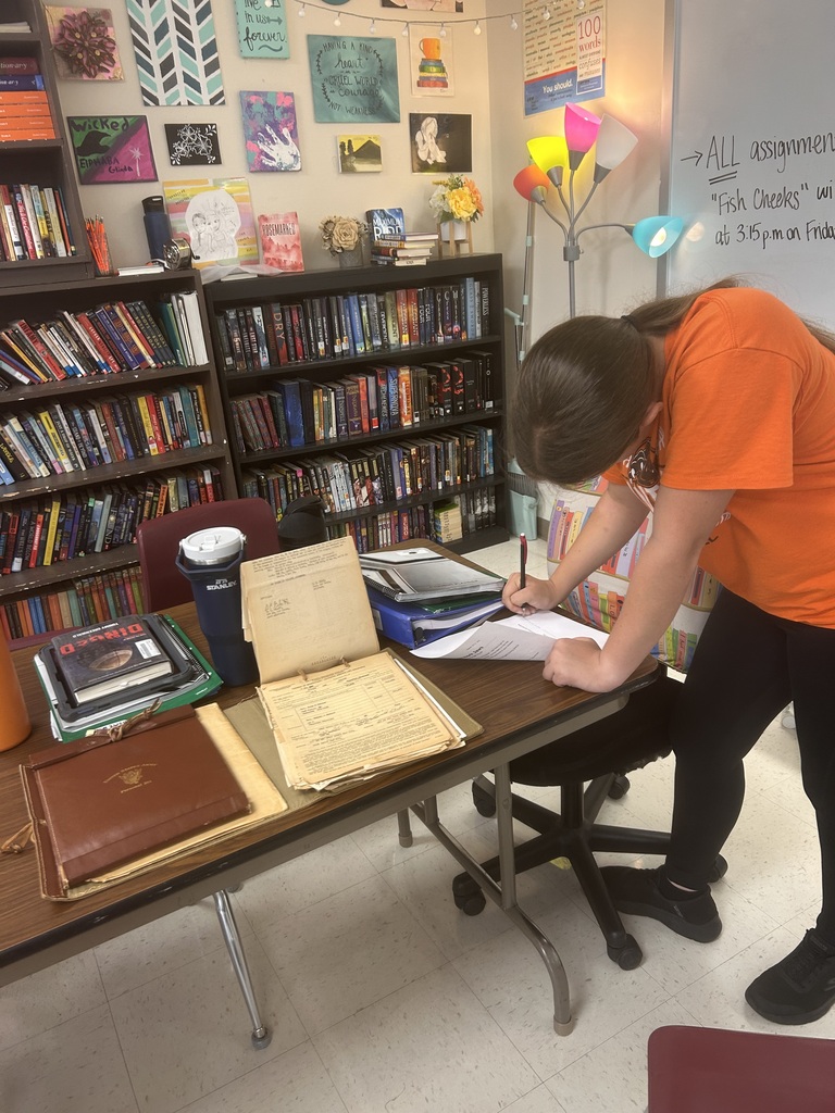 Student working on assignment related to WWII and looking at artifacts