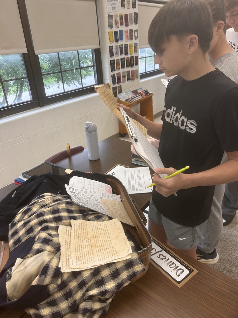 Student working on assignment related to WWII and looking at artifacts
