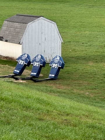 football tackling dummies with white shed behind it