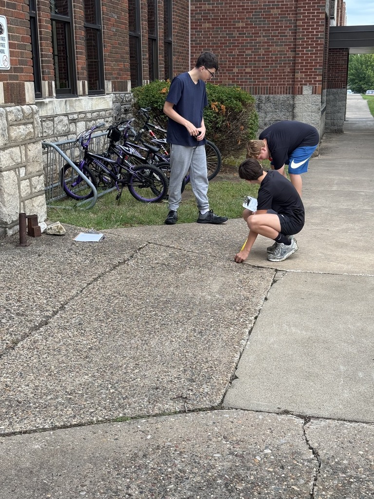 students measuring sidewalk outside middle school