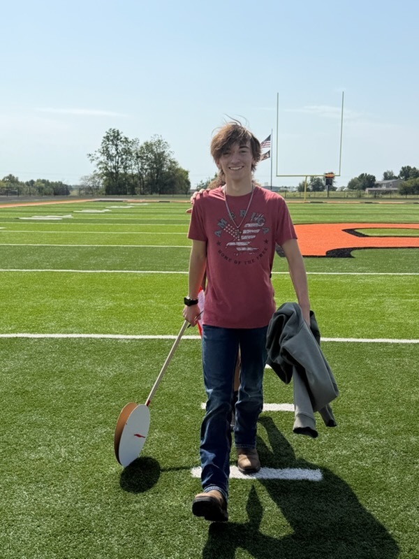 student using hodometer they made in class to measure distance on football field