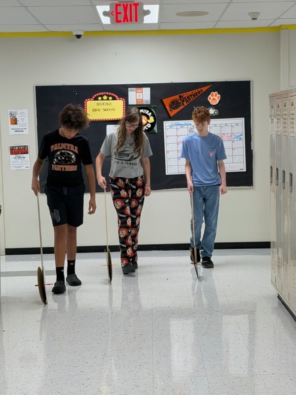 students using hodometers they made in class to measure distance in hallway