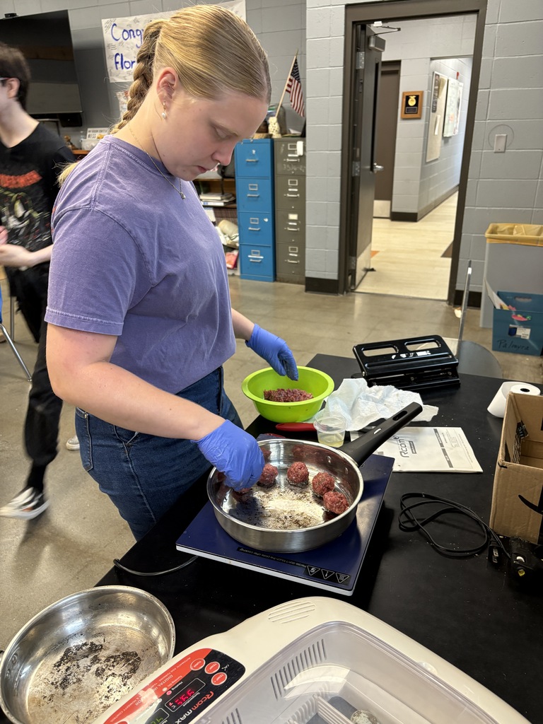 student cooking meatballs in class