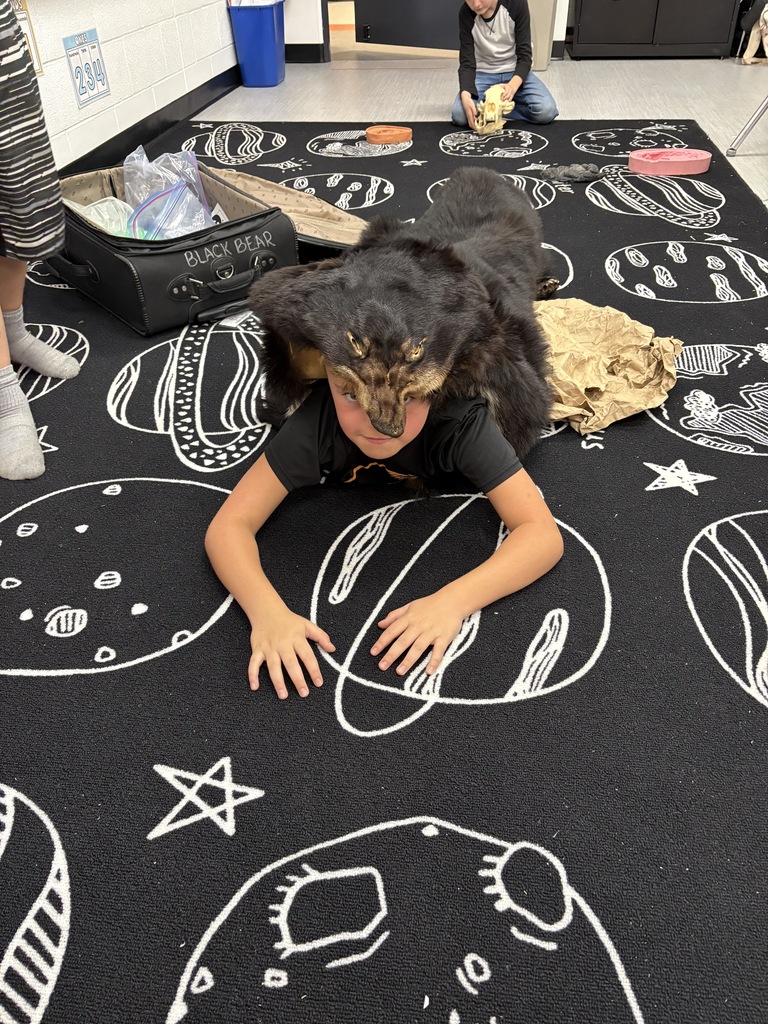 student with bear skin rug on his back